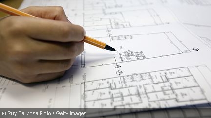 Bauplan mit Hand und Stift