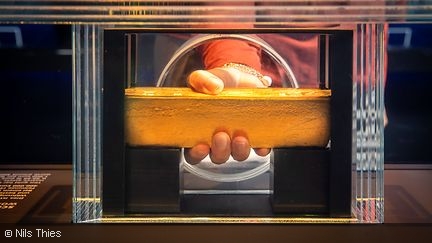 Visitor helds a gold bar in his hand