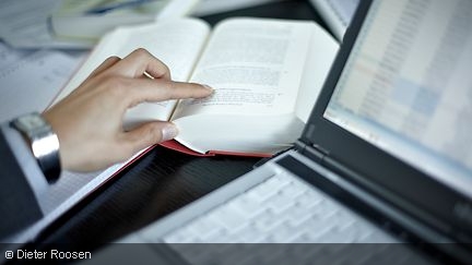 An open book next to a laptop