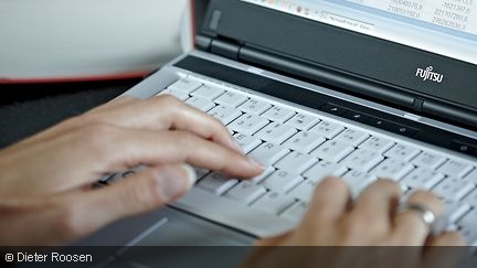 A woman's hands working on a notebook.